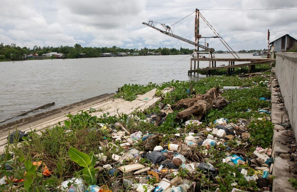 A polluted river in India heavily clogged with plastic waste, including bottles, bags, and debris, highlighting the environmental crisis caused by plastic pollution in water bodies.